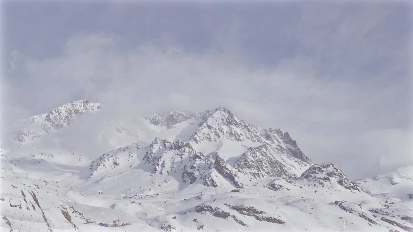Snow-covered mountain range under a cloudy sky